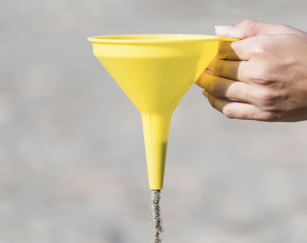 yellow plastic funnel with sand coming out