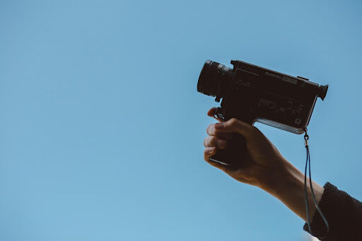 a person holding a camera filming a live action explainer video